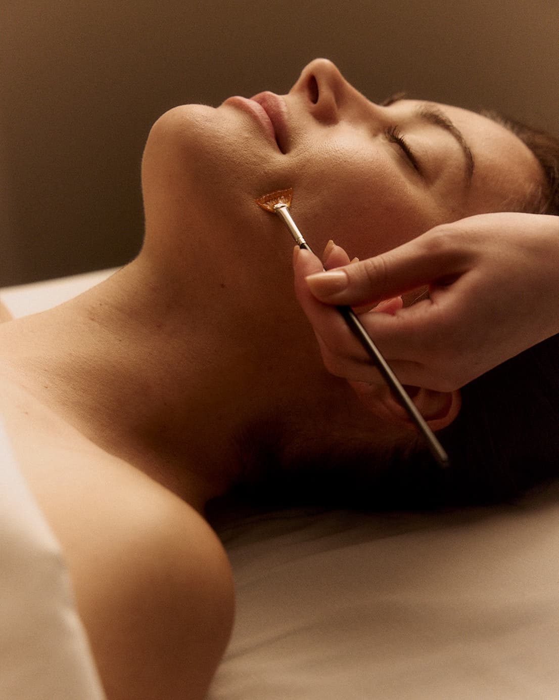 Woman receiving facial treatment at Hand & Stone Massage and Facial Spa
