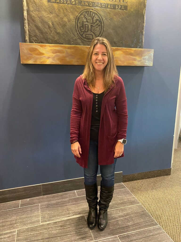 Sharon Slotkin standing in front of hand & stone signage