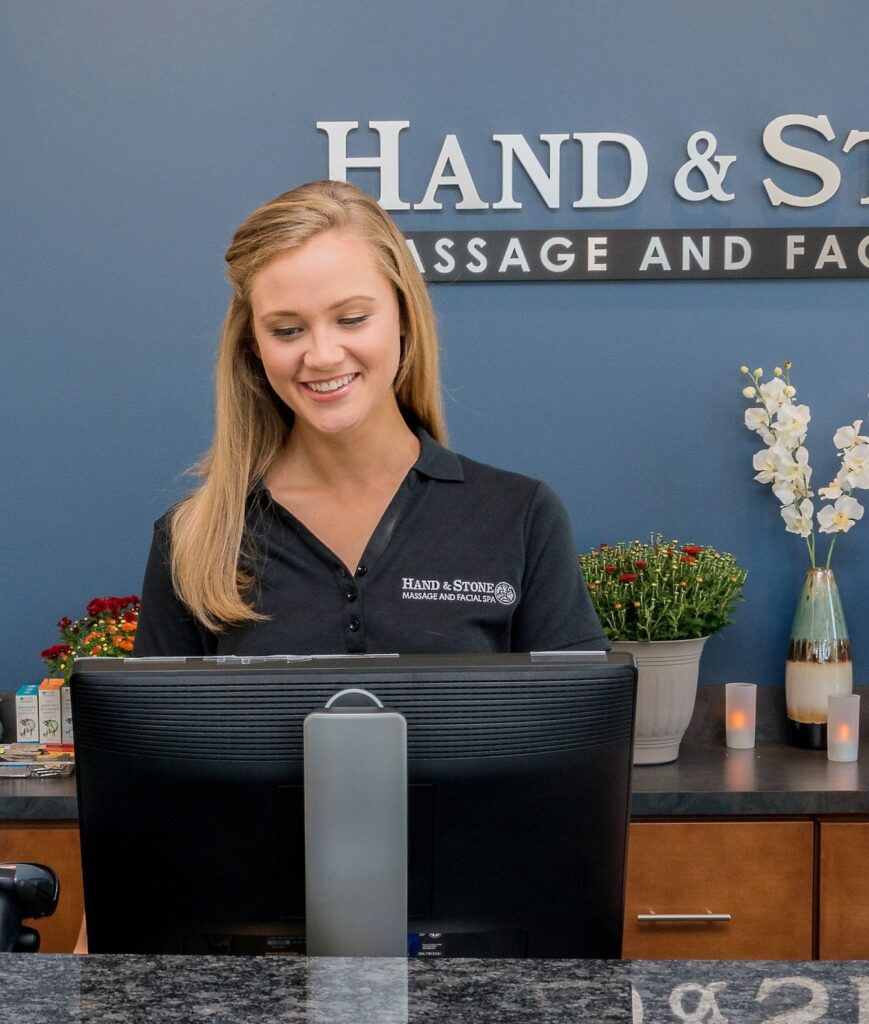 Receptionist working on computer in front desk lobby